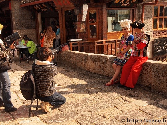 Couple in traditional Chinese clothing pose on Qinglong Bridge in Lijiang