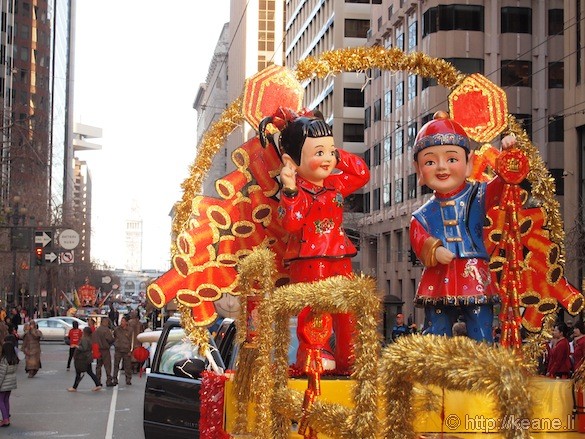 Chinese couple float for Chinese New Year parade with Ferry Building in background