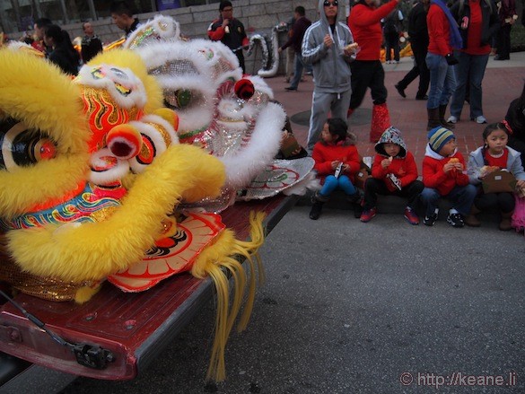 Chinese lion heads and kids eating before the Chinese New Year parade